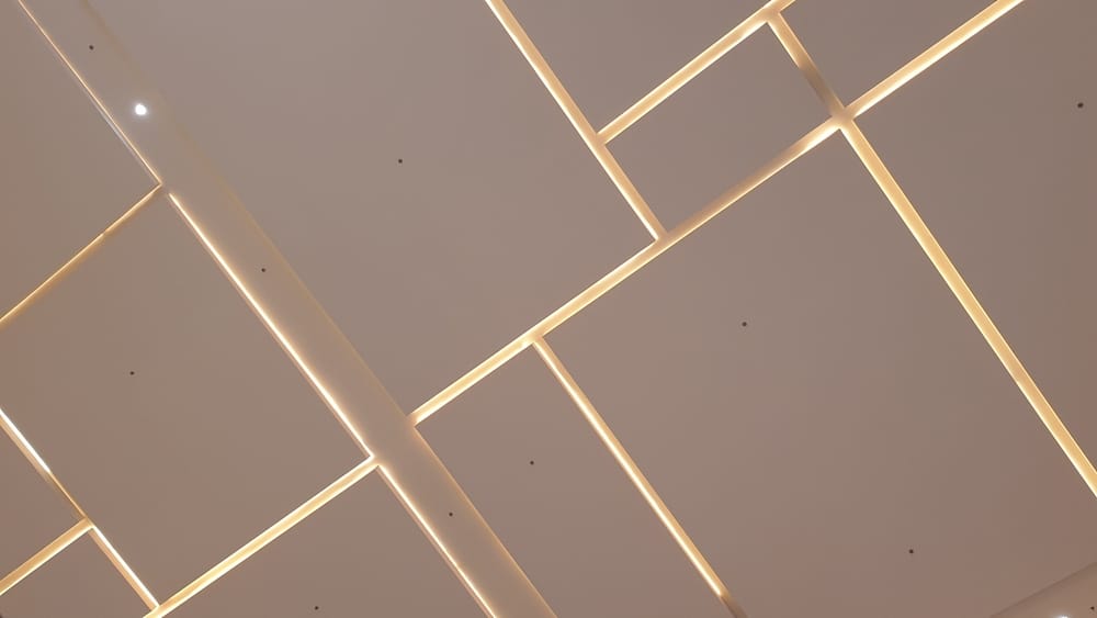 a,modern,architectural,ceiling,with,geometric,panel,design,illuminated,by